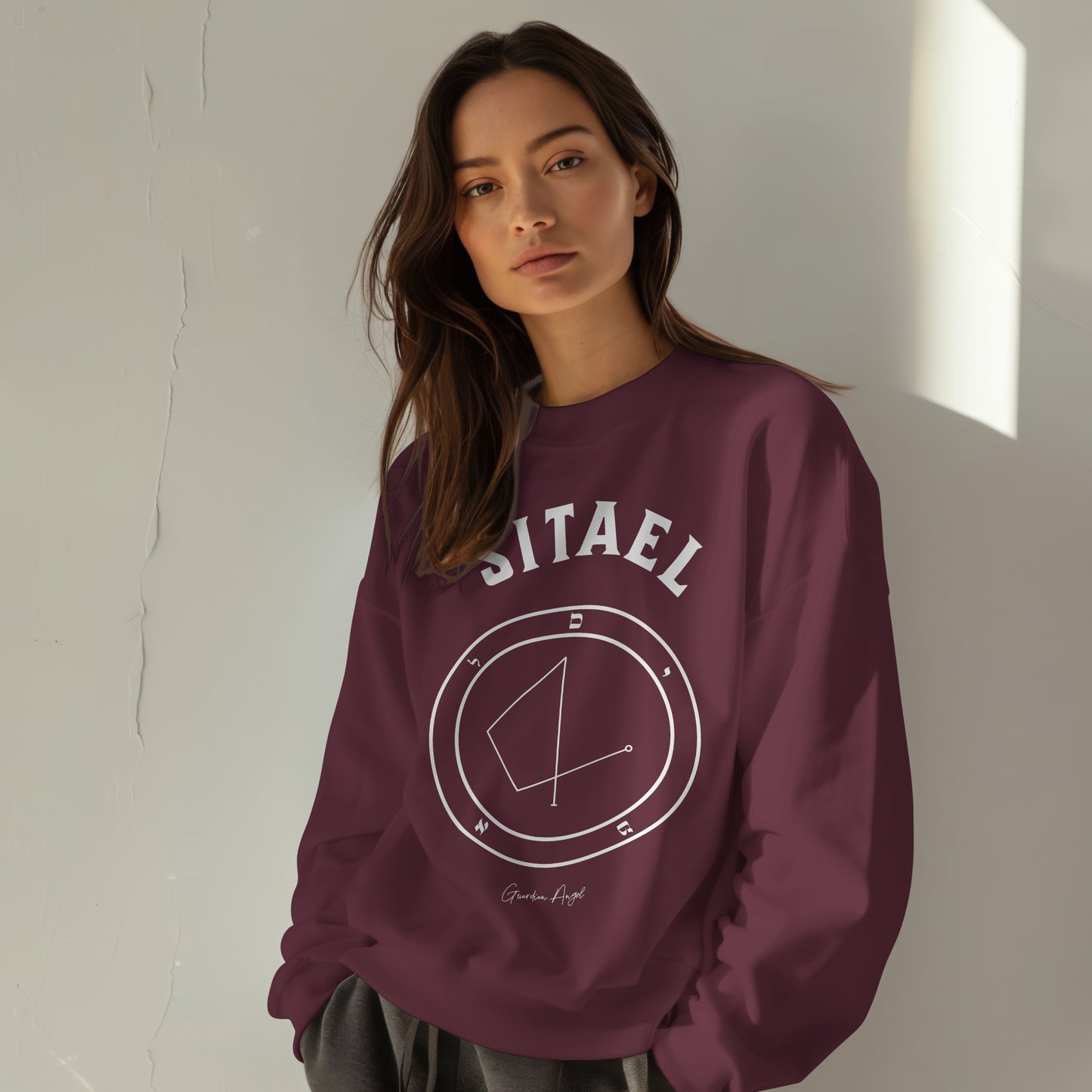 Model wearing a No.3 Shemhamphorasch Guardian Angel "Sitael" Sweatshirt in Maroon. With the seal of Sitael in white print on the front.