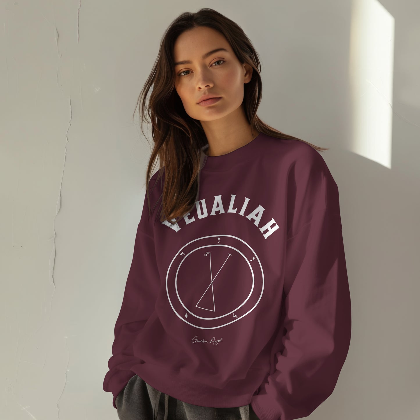 Model wearing a No.43 Shemhamphorasch Guardian Angel "Veualiah" Sweatshirt in Maroon. With the seal of Veualiah in white print on the front.