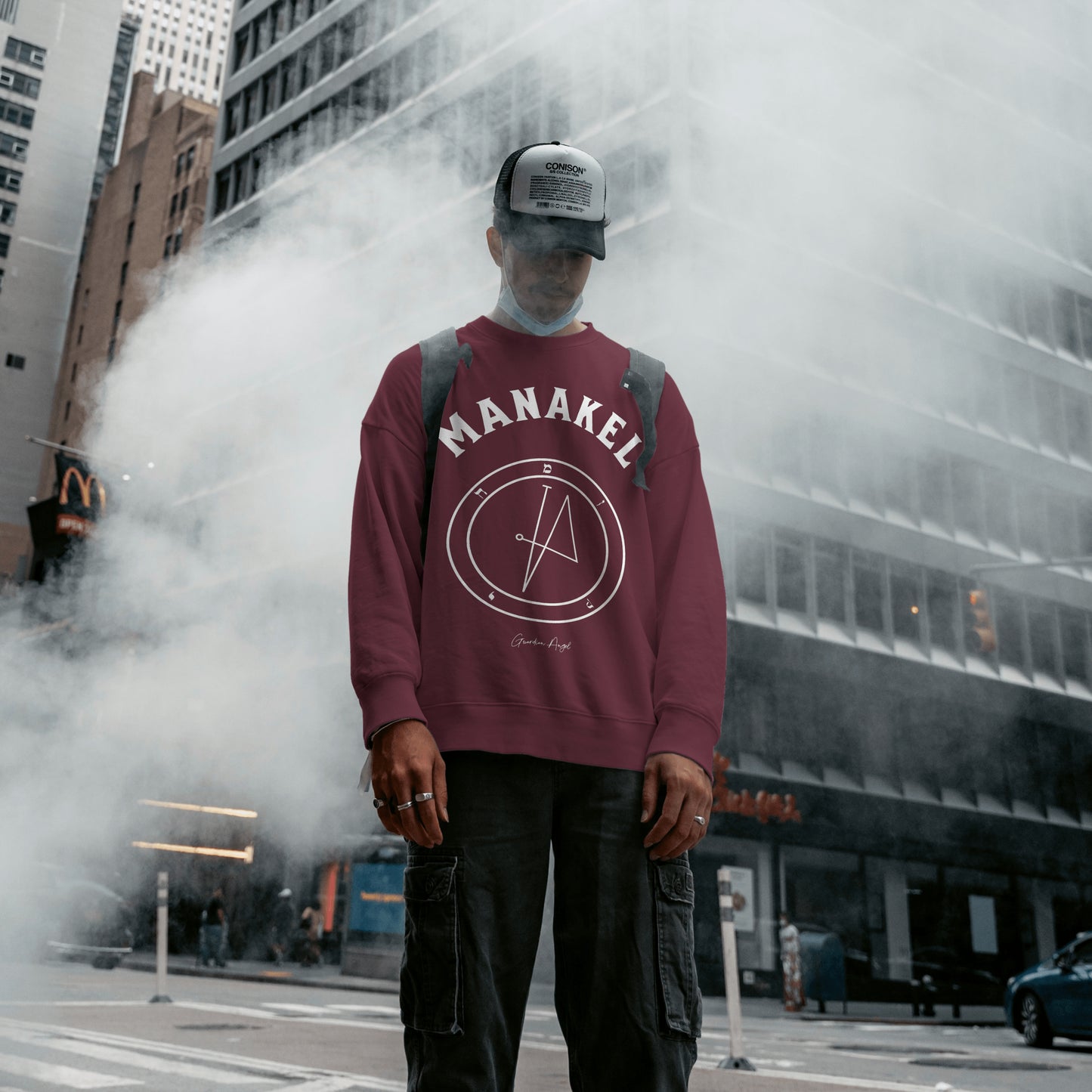 Model wearing a No.66 Shemhamphorasch Guardian Angel "Manakel" Sweatshirt in Maroon. With the seal of Manakel in white print on the front.