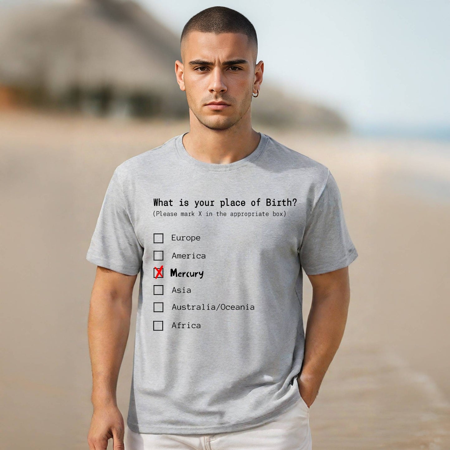 Man wearing a gray t-shirt with a humorous quiz design on a beach.