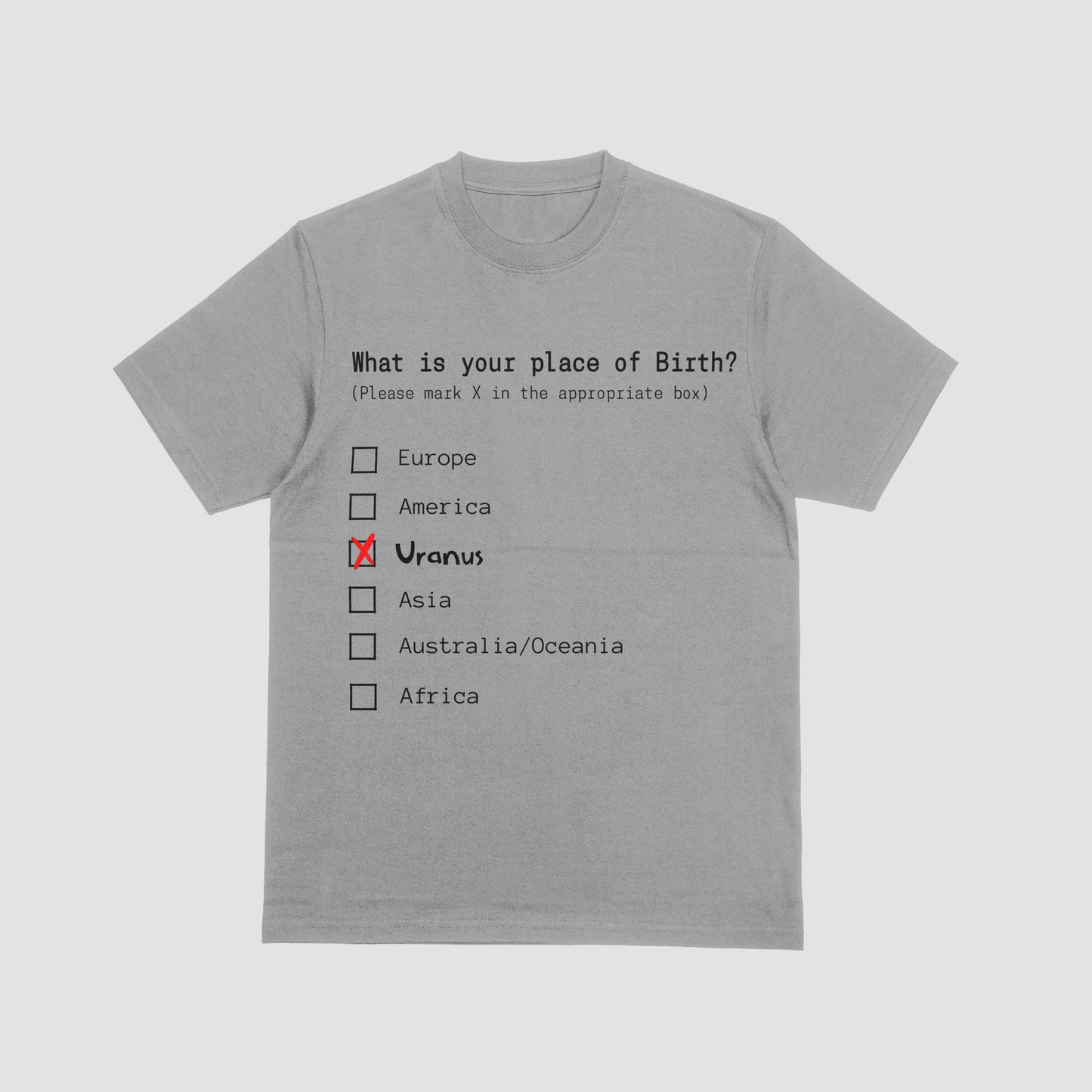 Gray t-shirt with a humorous 'place of birth' questionnaire design on a light gray background
