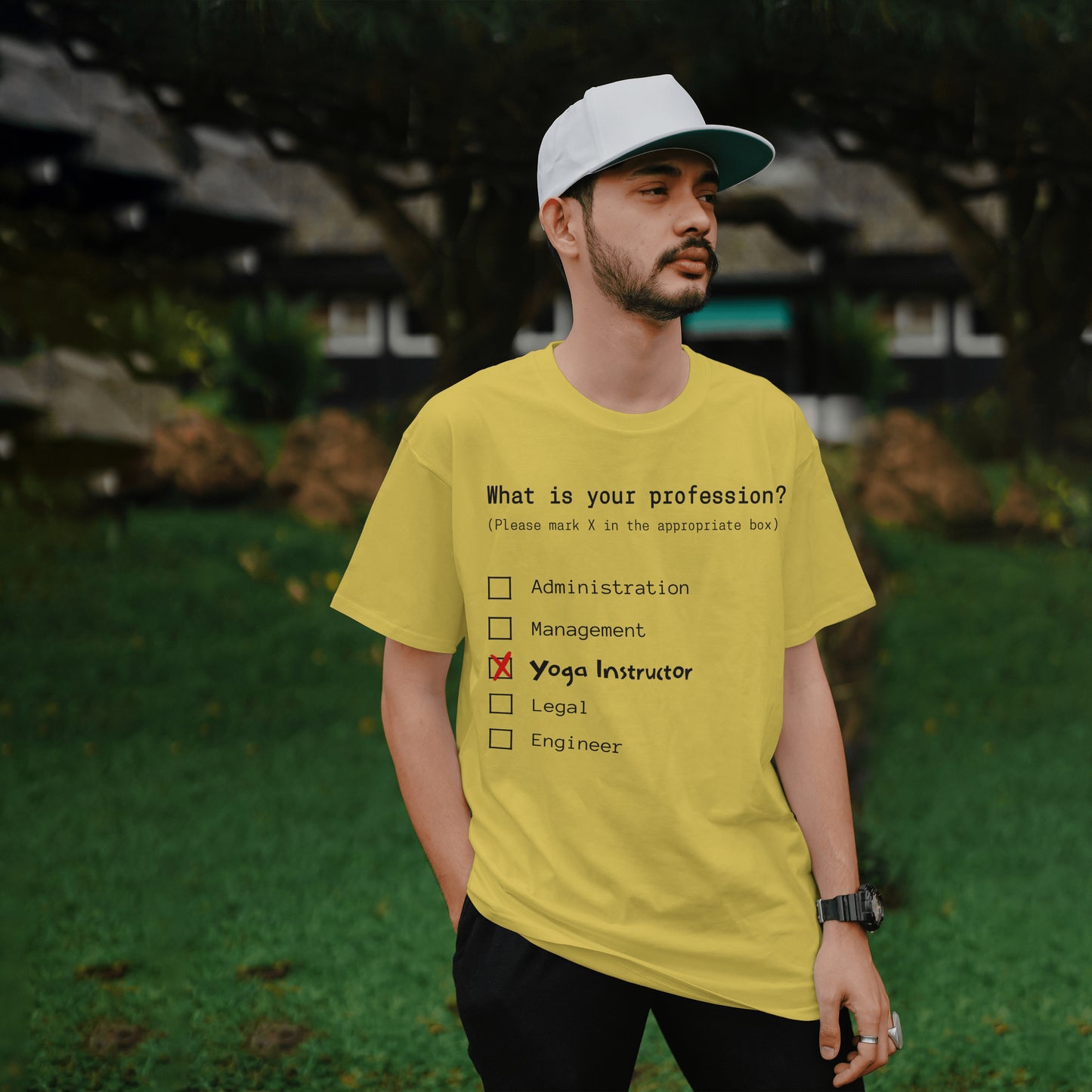 Man wearing a yellow t-shirt with a humorous profession quiz on a blurred natural background