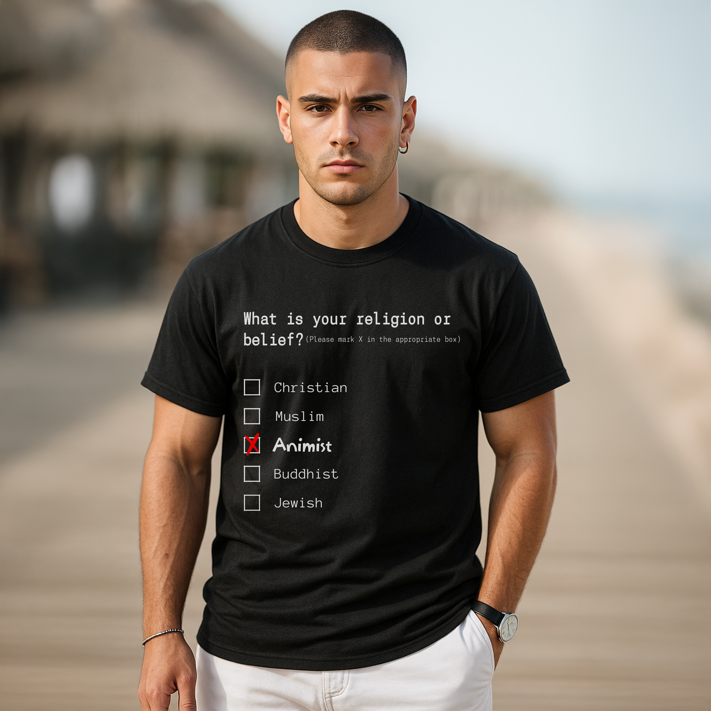 Man wearing a black t-shirt with a religious belief questionnaire on a blurred beach background