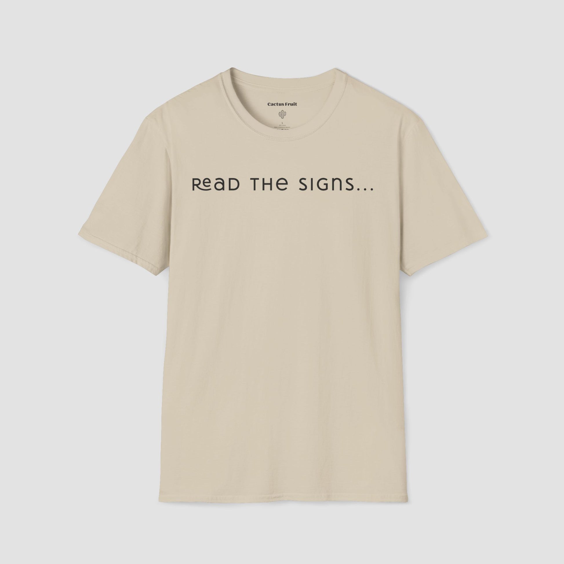 Beige t-shirt with 'READ THE SIGNS...' text on a light gray background