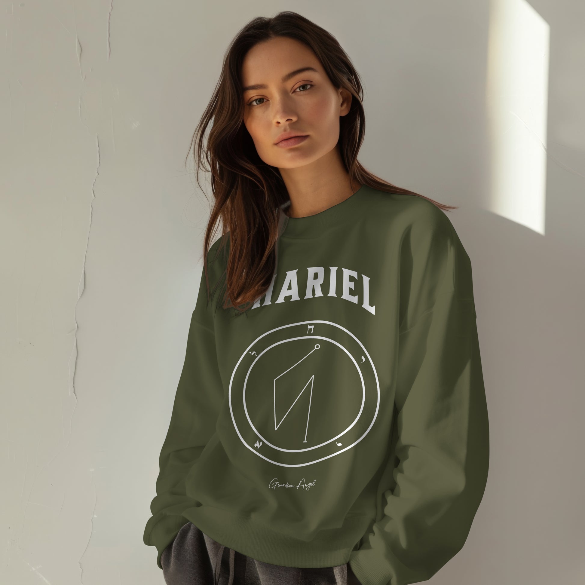 Model wearing a No.15 Shemhamphorasch Guardian Angel "Hariel"  Sweatshirt  in Military Green. With the seal of Hariel in white print on the front. 