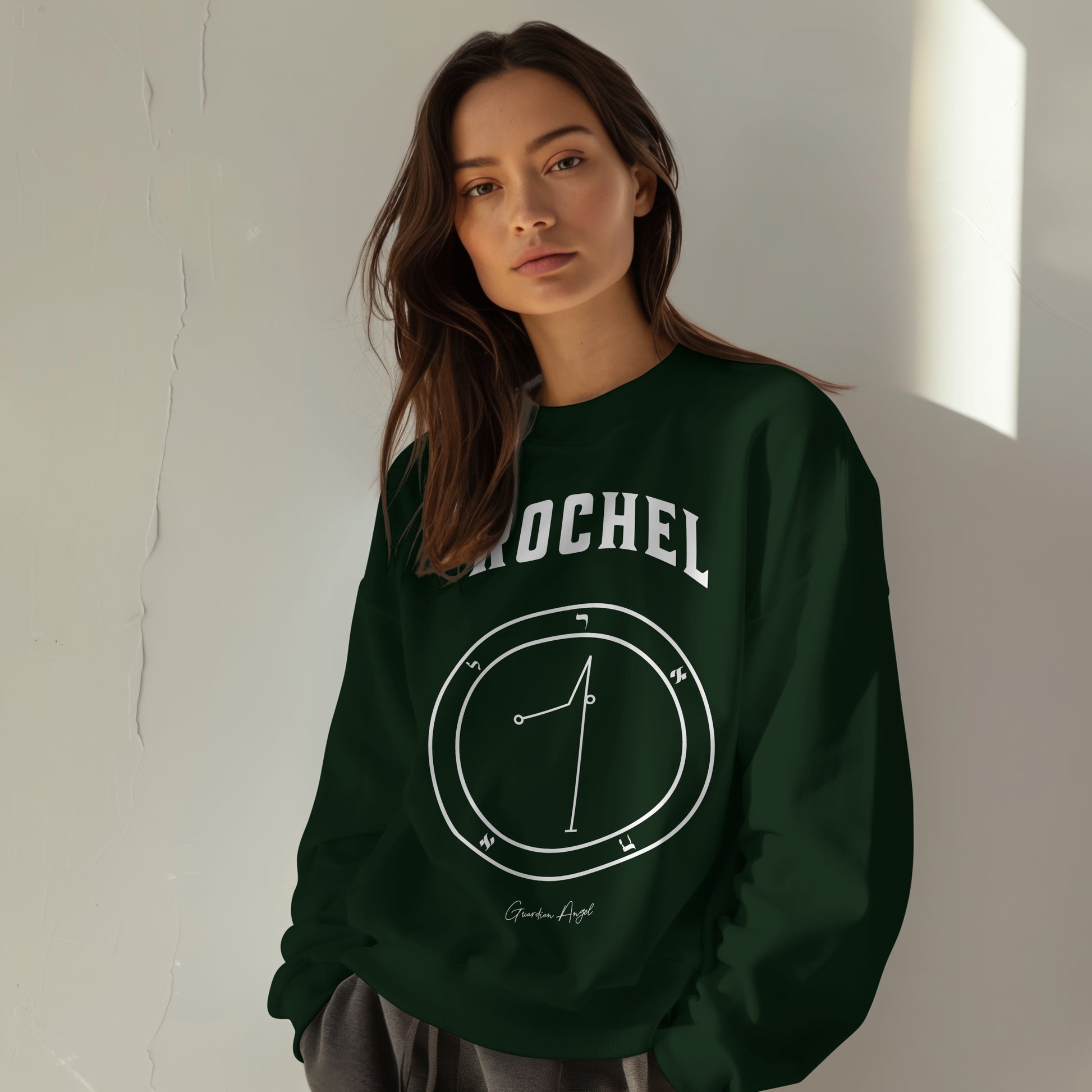 Model wearing a No.69 Shemhamphorasch Guardian Angel "Rochel"  Sweatshirt  in Forest Green. With the seal of Rochel in white print on the front.