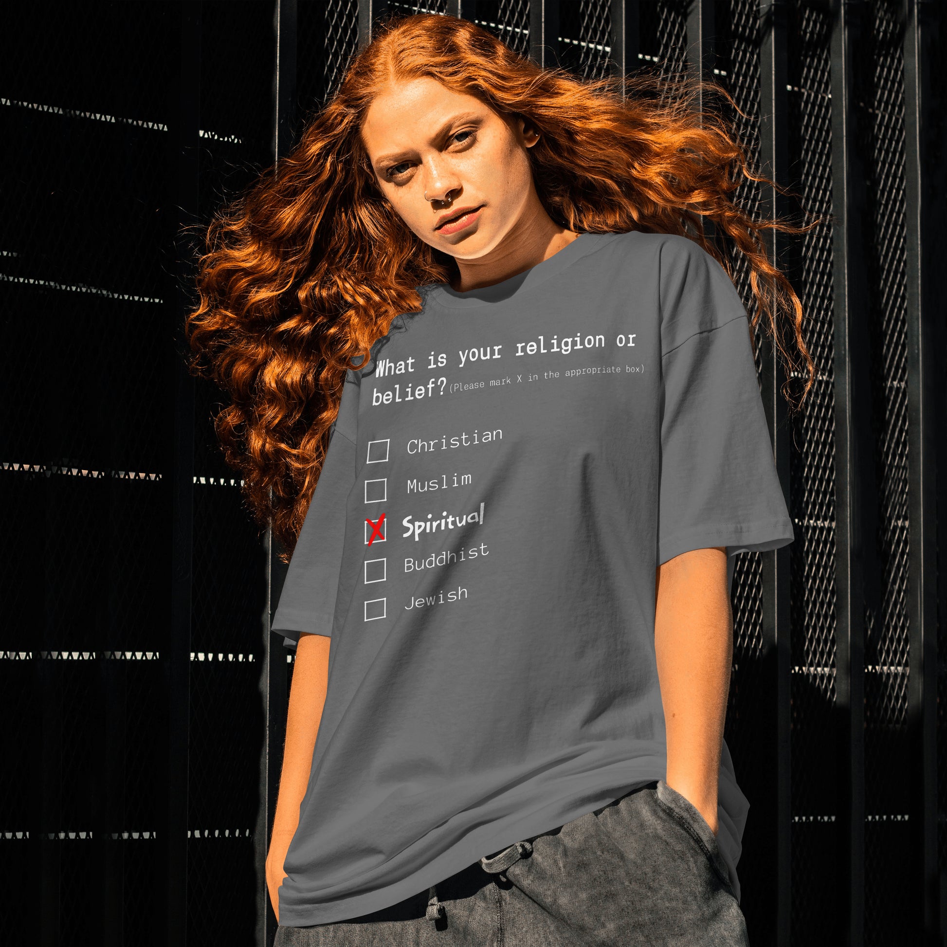 Person wearing a t-shirt with a religious belief questionnaire design against a black background.